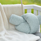 Eine mintfarbene Wickeltischrolle Musselin mit Pusteblumen von KraftKids GmbH ruht auf einer cremefarbenen, flauschigen Decke, die über eine weiße Holzbank im Freien drapiert ist.