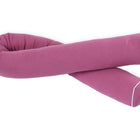 Eine lange, geschwungene Wickeltischrolle Musselin purpur der KraftKids GmbH mit weißer Paspelierung an den Rändern, dargestellt in einer lockeren, gedrehten Form auf weißem Hintergrund.