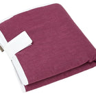 Die KraftKids Reisewickelunterlage Leinen magenta dunkel, eine kompakte kastanienbraune Reisewickelunterlage mit weißem Rand und Gurt, ist gefaltet auf weißem Hintergrund abgebildet - perfekt als platzsparende Wickelauflage für unterwegs.