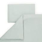 Ein fein säuberlich gefaltetes KraftKids Bettwäscheset Musselin in Grün mit goldenen Punkten, aus 100% Baumwolle für erholsamen Schlaf. Von oben auf weißem Hintergrund gezeigt, enthält das Set einen Kissenbezug und ein teilweise gefaltetes Laken.