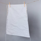 Der KraftKids Sonnensegel weiße Punkte auf Grau, mit weißen Punkten auf grauem luftdurchlässigem Stoff, hängt auf einer Wäscheleine vor einem schlichten grauen Hintergrund.