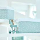 Zwei mintfarbene Körbchen Musselin Pusteblumen von KraftKids mit weißem Pusteblumenmuster und weißem Rand sowie ein passendes Spielzeugpferd stehen auf weißen Regalen in einem hellen Raum.