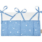 Die KraftKids Betttasche abgerundete Dreiecke weiß auf Blau ist ein handgefertigter blau-weißer Organizer für das Kinderzimmer, mit drei oberen Schleifen, kleinen weißen geometrischen Mustern, Seitenetikett und praktischen Taschen.