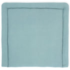 Eine weiche, quadratische KraftKids Wickelauflage Musselin mint mit erhabenen Rändern wird von oben vor einem weißen Hintergrund betrachtet.