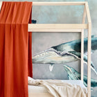 Die KraftKids Bettbaldachin Doppelkrepp Rot Herbstrot bringt Wärme in ein Holzhausbett, das vor einer blauen Wal-Wandmalerei steht. Ideal als Kinderzimmer Deko, verfügt das Bett über eine weiche cremefarbene Decke für eine gemütliche, verträumte Schlafumgebung.