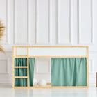 Ein minimalistisches Kinderbett mit dem KraftKids Hochbettvorhänge Set 2+1 Doppelkrepp Grün Jade für das Kura Bett, einem Rahmen aus Naturholz, grünen Vorhängen, einer kleinen Leiter und Dekorakzenten an der weiß getäfelten Wand.