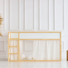 Ein minimalistisches Kinderspielhaus zeigt das KraftKids Hochbettvorhänge Set 2+1 Musselin Zweige braun, entworfen für Kura Bett, mit hellem Holzrahmen und gemusterten Vorhängen, in einem hellen Raum mit Pampasgras und Holzklötzen.